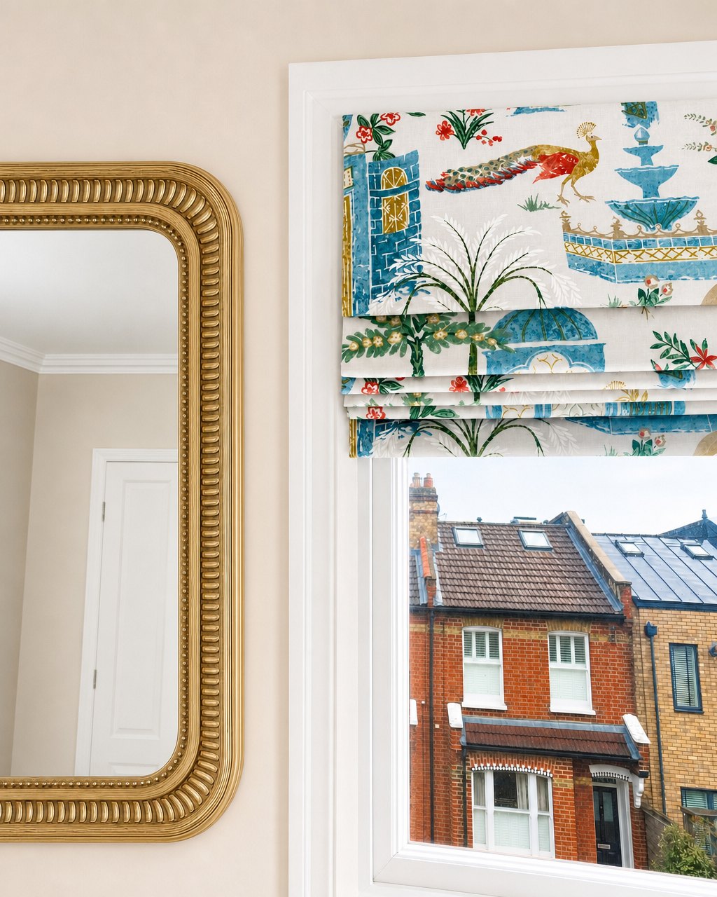 Patterned Roman blind beside a mirror