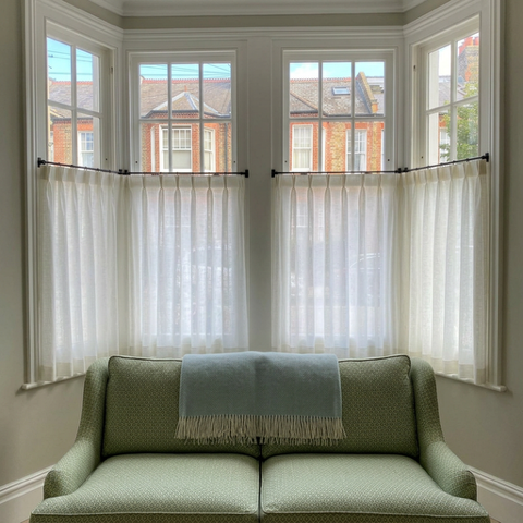 White cafe curtains in a bay window